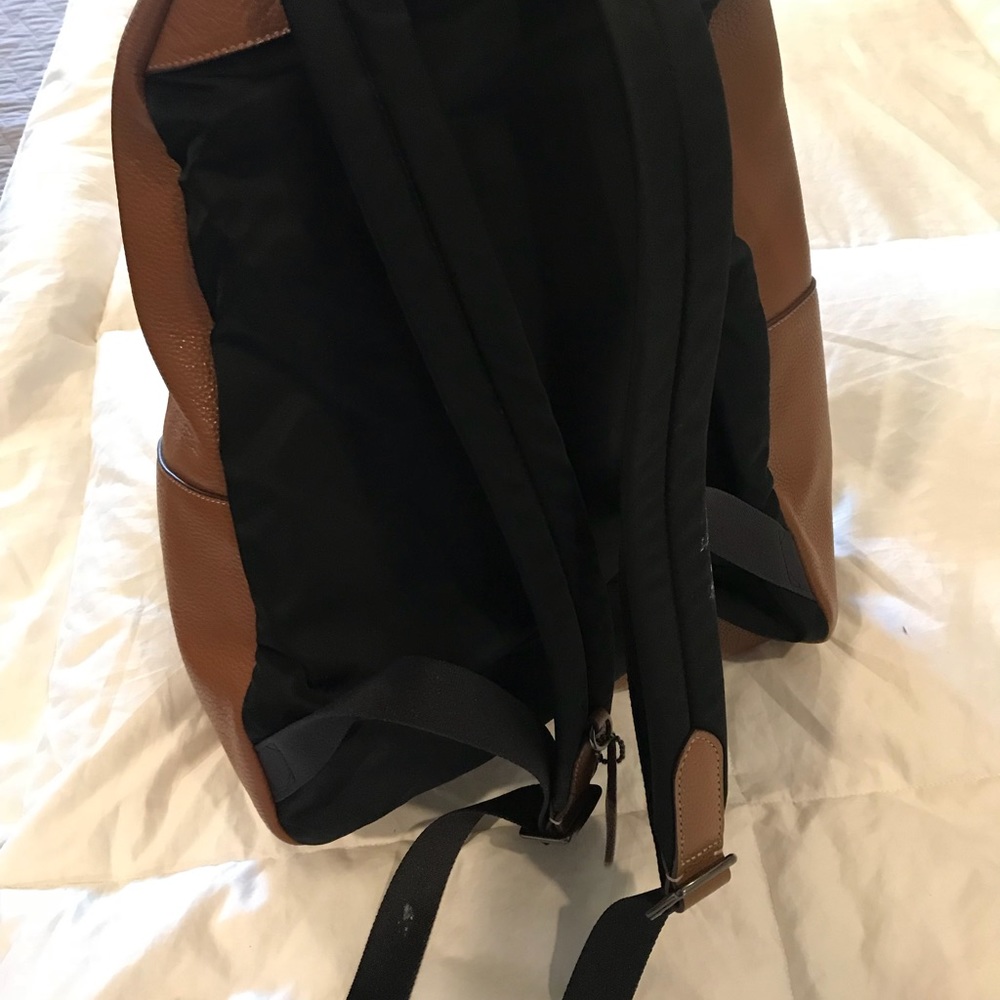 A light brown leather Coach backpack